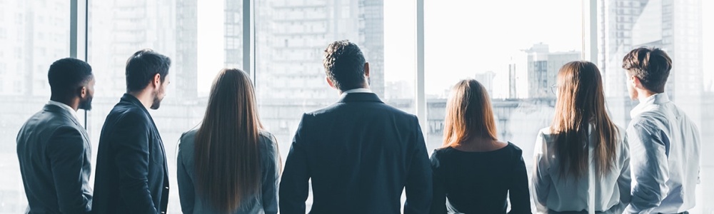 Businesspeople having break at meeting, looking through window, back view